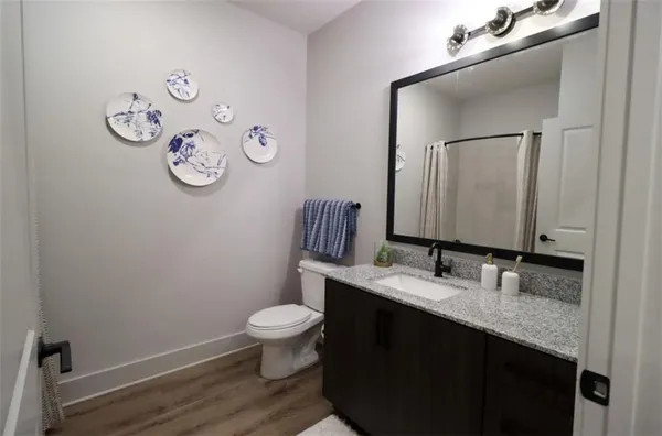 a bathroom with a granite countertop sink toilet and mirror