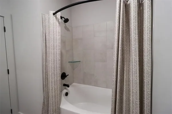 a bathroom with bathtub and shower