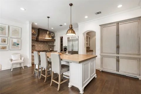 a kitchen with stainless steel appliances kitchen island granite countertop a stove a sink and a refrigerator
