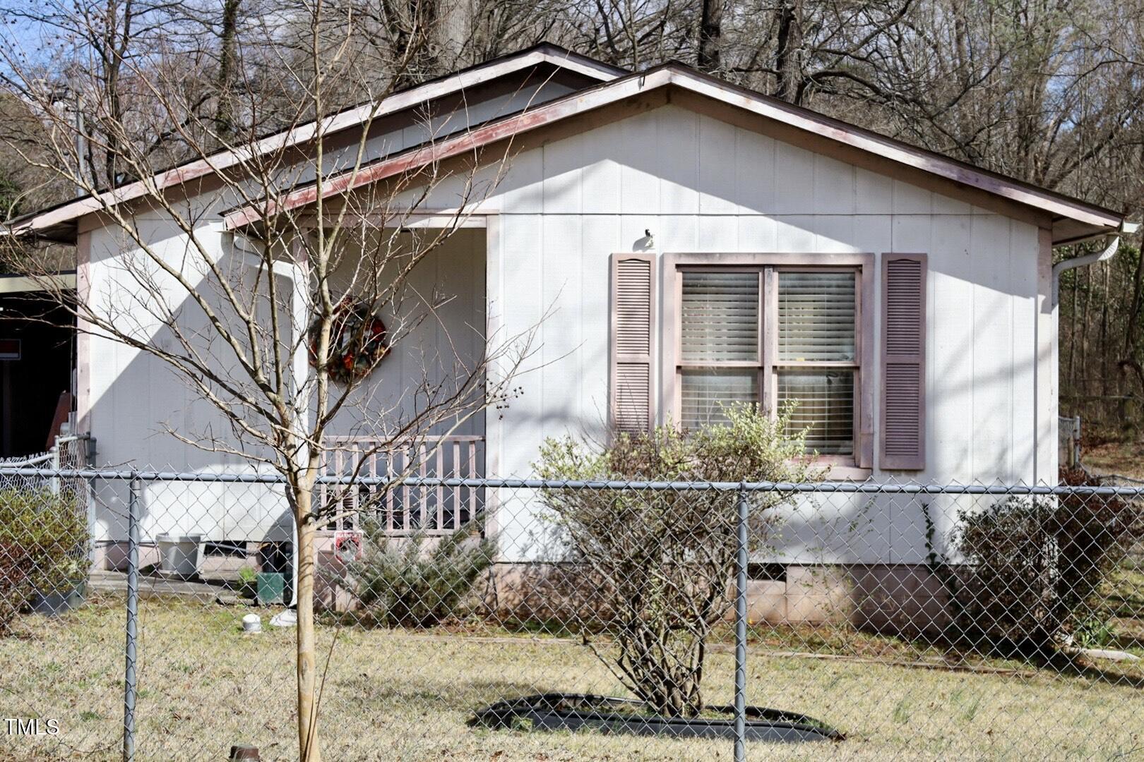 a house that has a small yard and large trees