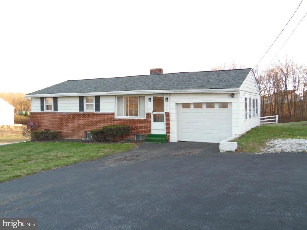 a view of a house with a yard and potted plants