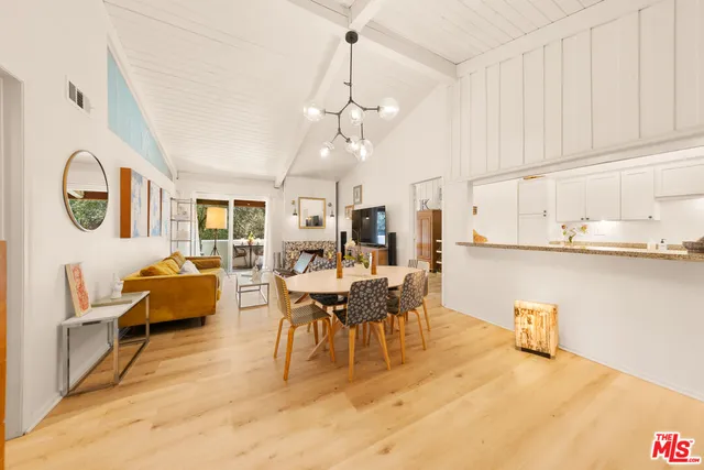 a dining room with furniture and view of kitchen