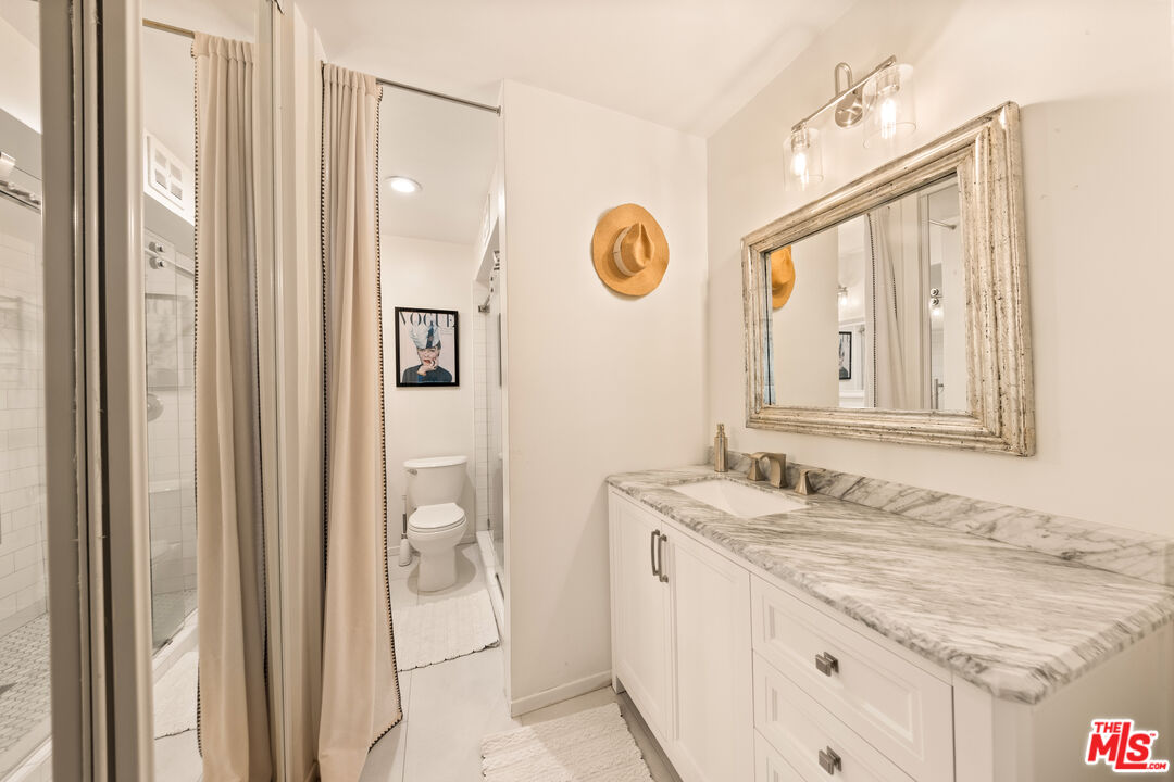 6425 Green Valley Circle, Unit 302 Culver City, CA 90230 - Photo 16 of 34 a bathroom with a granite countertop sink and a mirror