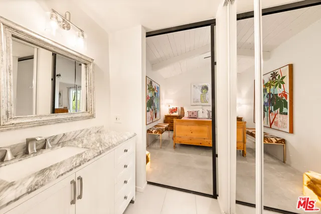 a en suite bathroom with a granite countertop double vanity sink a mirror and a shower