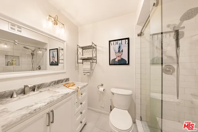 a bathroom with a granite countertop toilet sink and shower