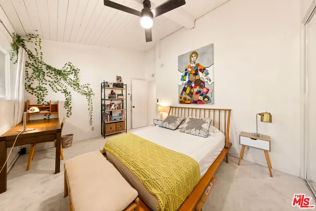 a bedroom with a bed and a large window