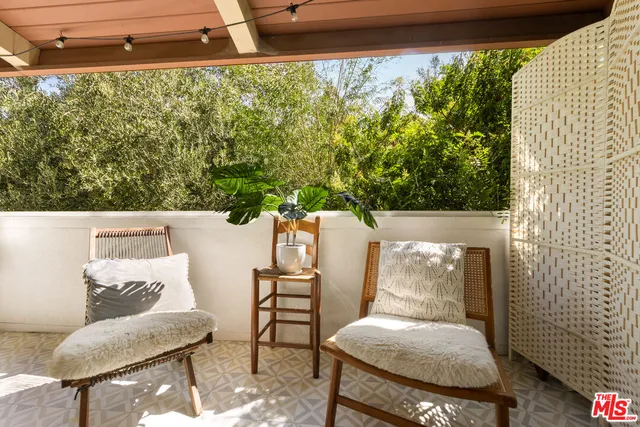 a living room with furniture a flat screen tv and floor to ceiling window