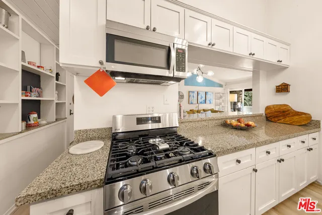 a kitchen with stainless steel appliances granite countertop a stove and a microwave