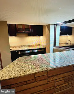 a kitchen with granite countertop a sink and a stove
