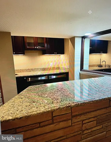 a kitchen with granite countertop a sink and a stove