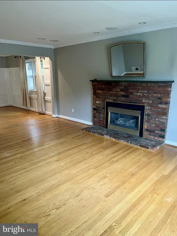 a view of empty room with wooden floor and fireplace
