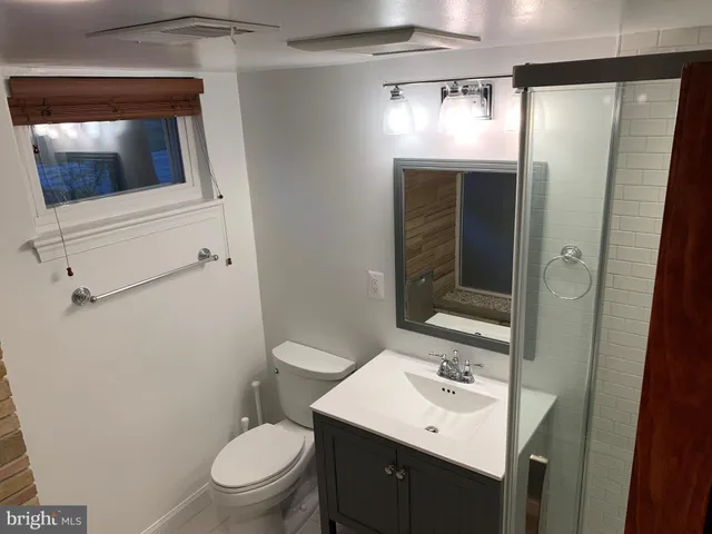 a bathroom with a sink a toilet a mirror and vanity