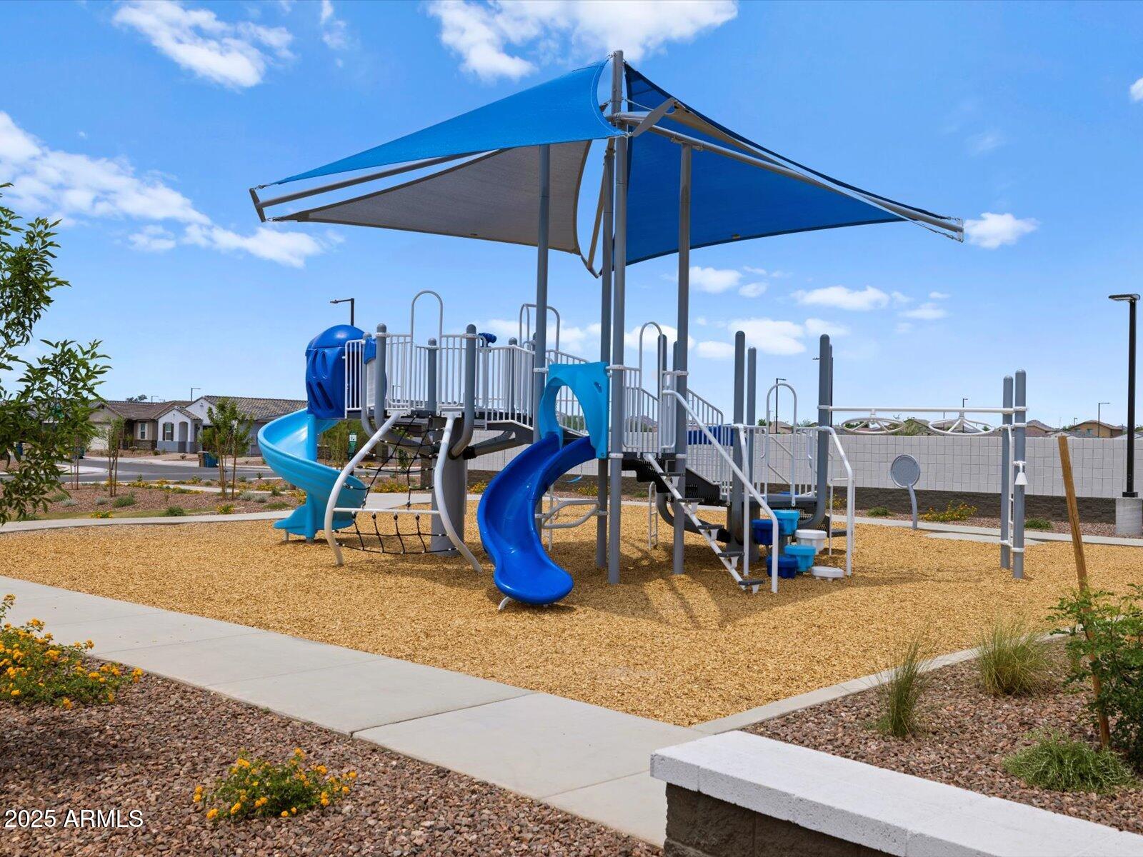 24477 West Grove Street Buckeye, AZ 85326 - Photo 38 of 49 a view of a swimming pool with a table and chairs under an umbrella