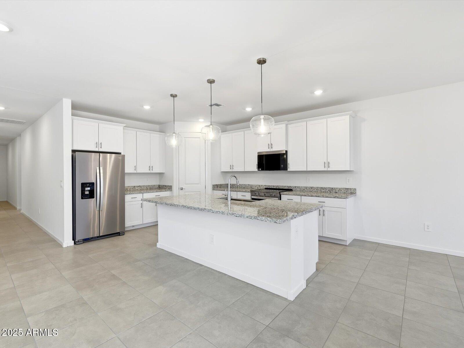 24477 West Grove Street Buckeye, AZ 85326 - Photo 3 of 49 a kitchen with stainless steel appliances kitchen island sink refrigerator and microwave