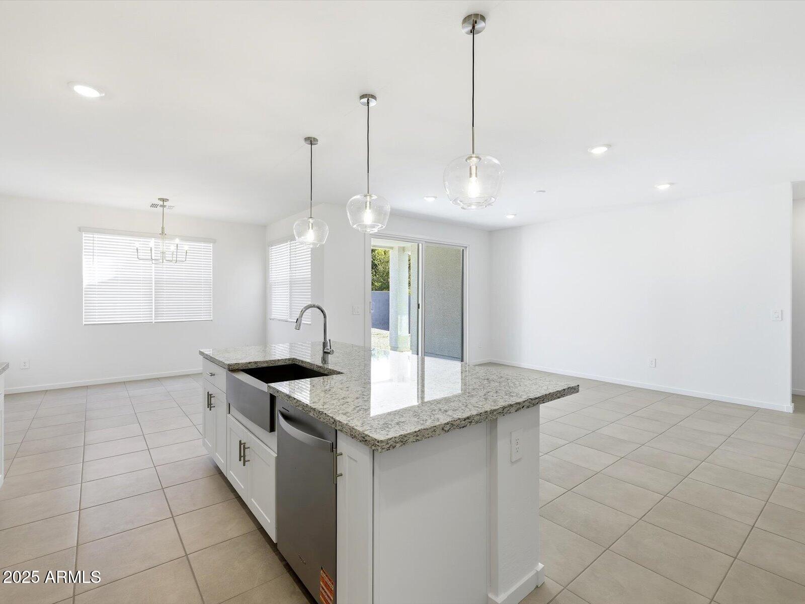 24477 West Grove Street Buckeye, AZ 85326 - Photo 7 of 49 a kitchen with granite countertop a sink a counter top space and cabinets