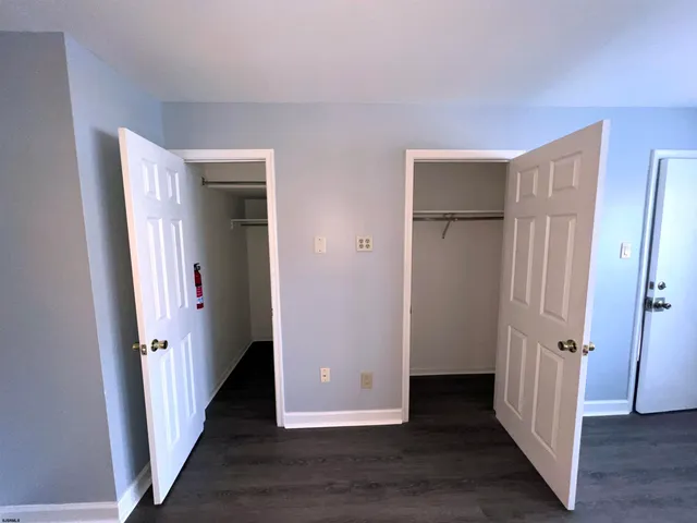 an empty room with wooden floor and entrance