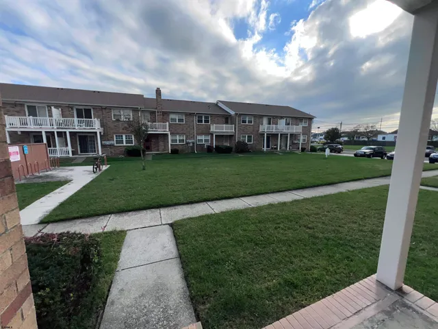 a view of a big house with a big yard and large trees