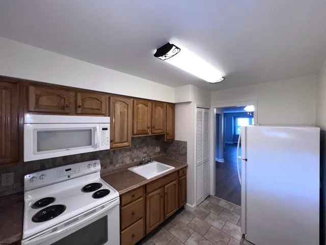 a kitchen with stainless steel appliances kitchen island granite countertop a stove a microwave and a refrigerator