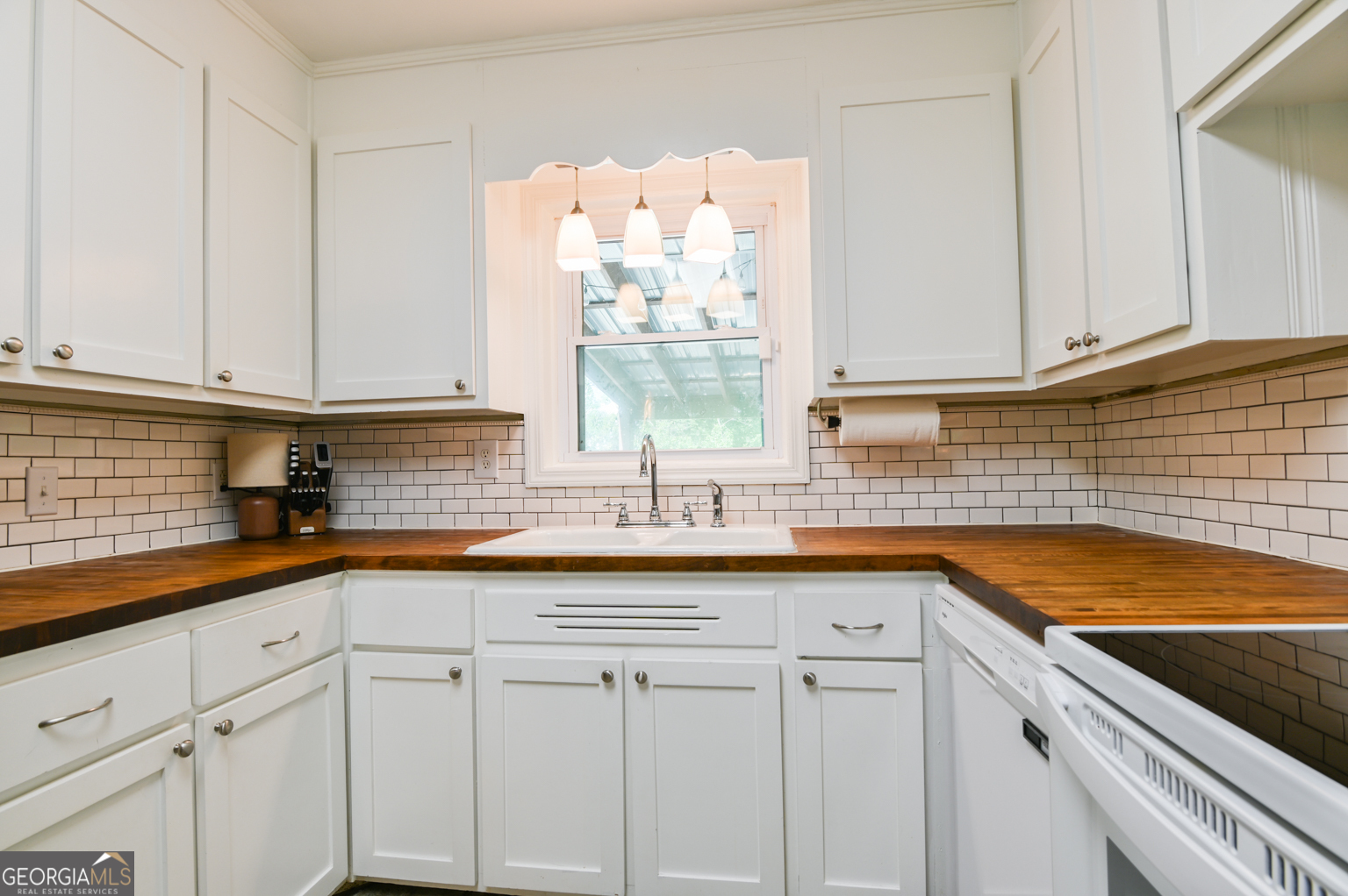 545 Forest Hill Road Macon, GA 31210 - Photo 33 of 63 a kitchen with granite countertop white cabinets and white appliances