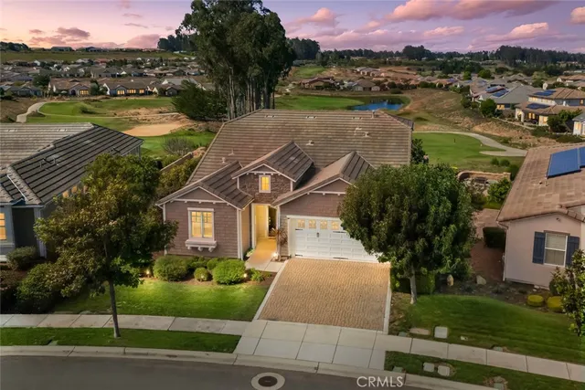 a front view of a house with a yard and lake view