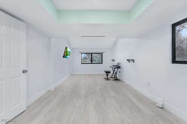 a bed sitting in a spacious bedroom next to a window