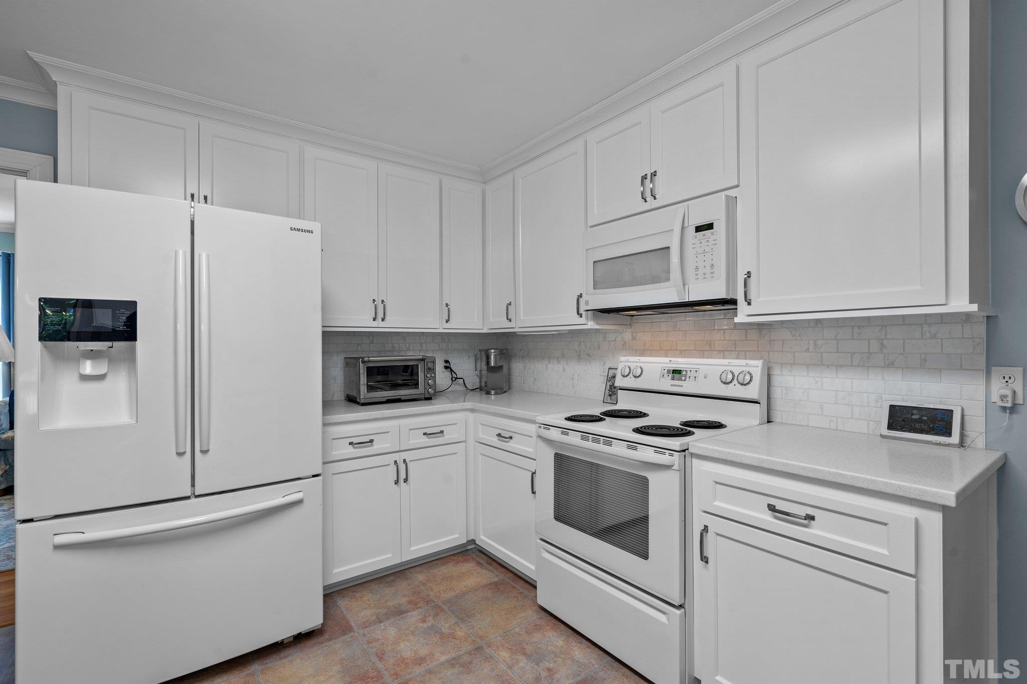 7805 Harps Mill Road Raleigh, NC 27615 - Photo 18 of 57 a kitchen with white cabinets and white appliances