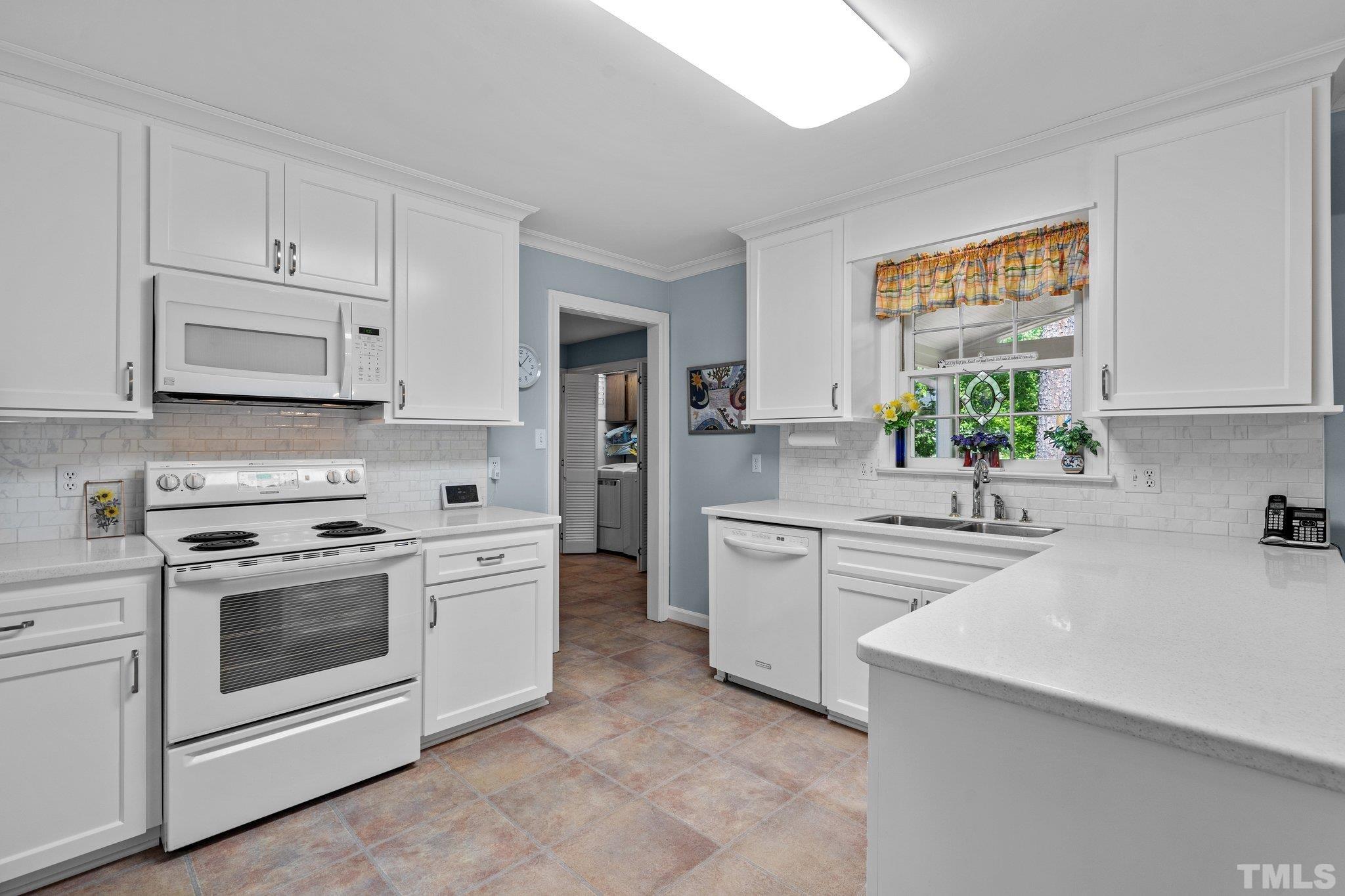 7805 Harps Mill Road Raleigh, NC 27615 - Photo 19 of 57 a kitchen with stainless steel appliances white cabinets and white appliances