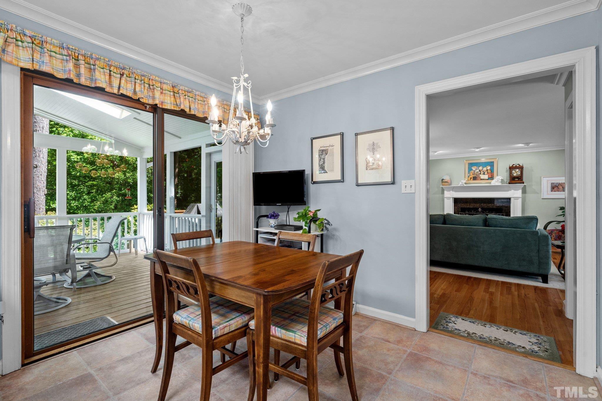 7805 Harps Mill Road Raleigh, NC 27615 - Photo 23 of 57 a view of a dining room with furniture wooden floor and chandelier