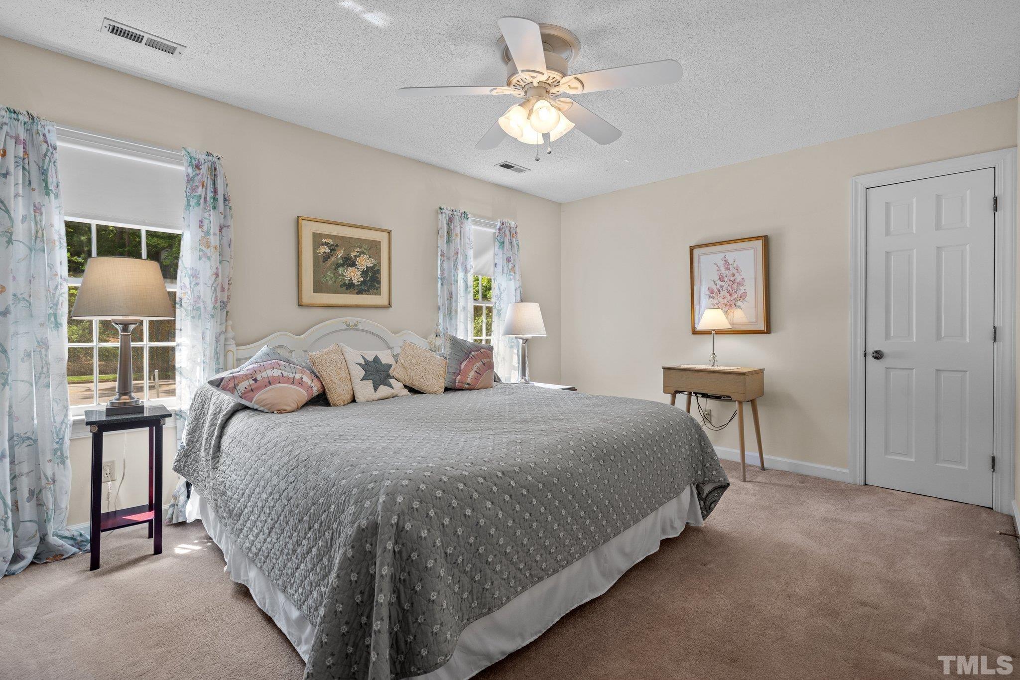 7805 Harps Mill Road Raleigh, NC 27615 - Photo 32 of 57 a bedroom with a bed and a chandelier