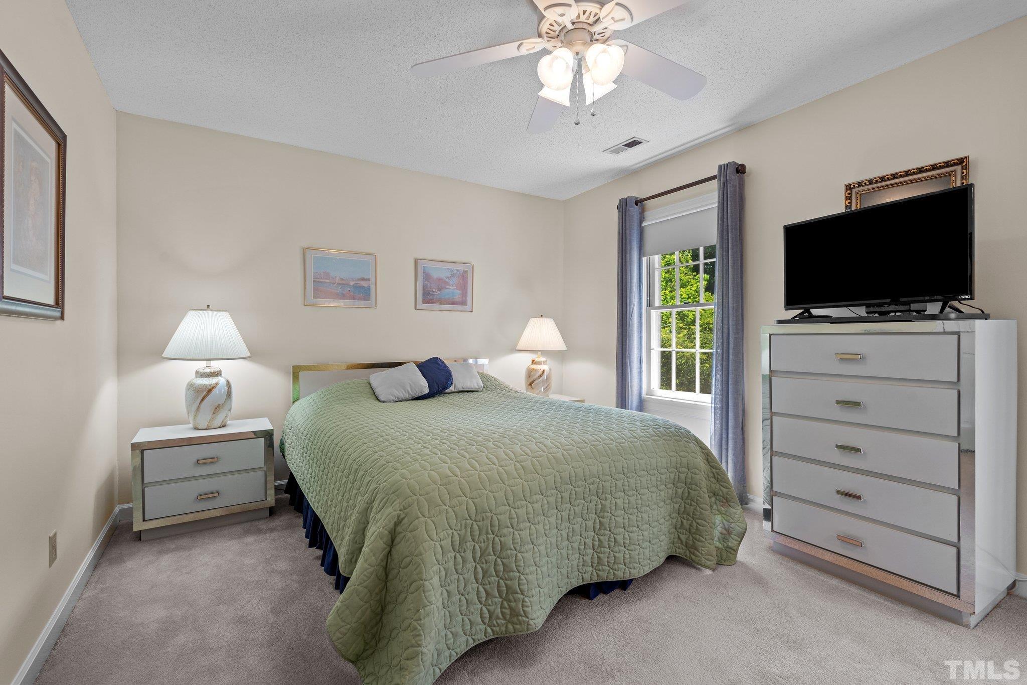 7805 Harps Mill Road Raleigh, NC 27615 - Photo 34 of 57 a bedroom with a bed and a flat screen tv