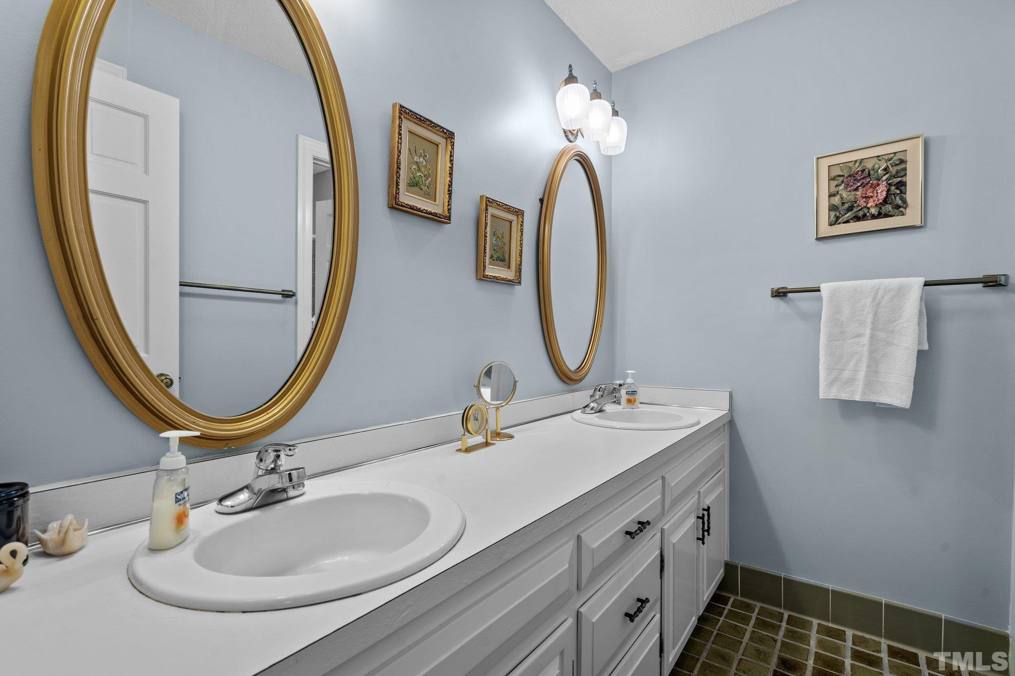 7805 Harps Mill Road Raleigh, NC 27615 - Photo 36 of 57 a bathroom with a double vanity sink and a mirror