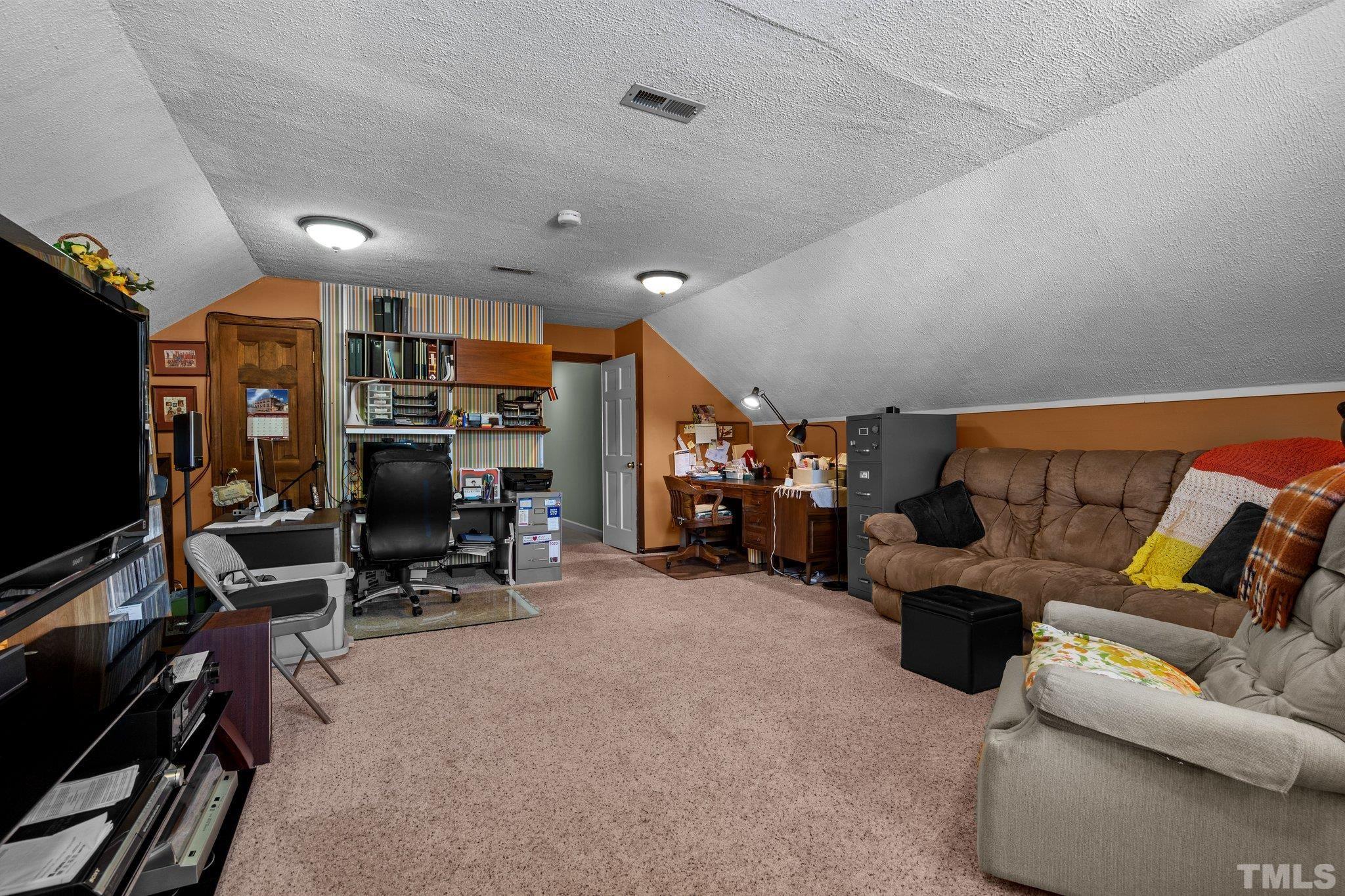 7805 Harps Mill Road Raleigh, NC 27615 - Photo 40 of 57 a living room with furniture and a flat screen tv