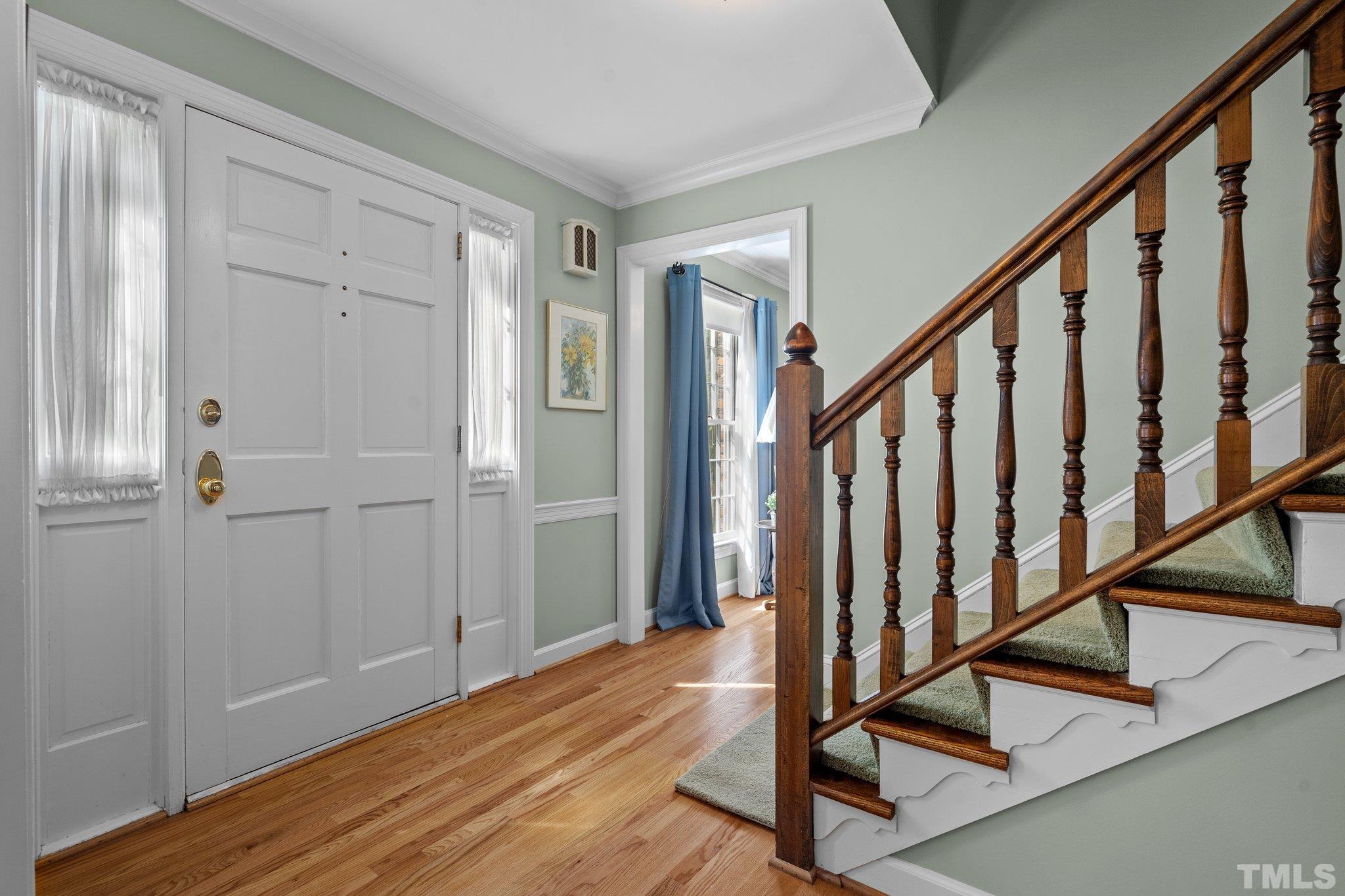 7805 Harps Mill Road Raleigh, NC 27615 - Photo 9 of 57 a view of a hallway with wooden floor and staircase