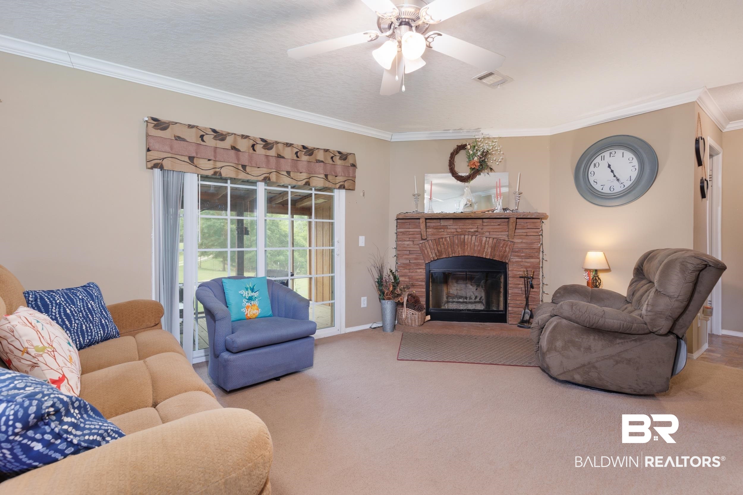 6725 Upper Creek Road Flomaton, AL 36441 - Photo 36 of 61 Living area with ornamental molding, carpet floors, a ceiling fan, baseboards, and a fireplace