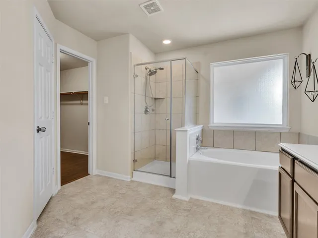 a bathroom with a tub shower and a sink