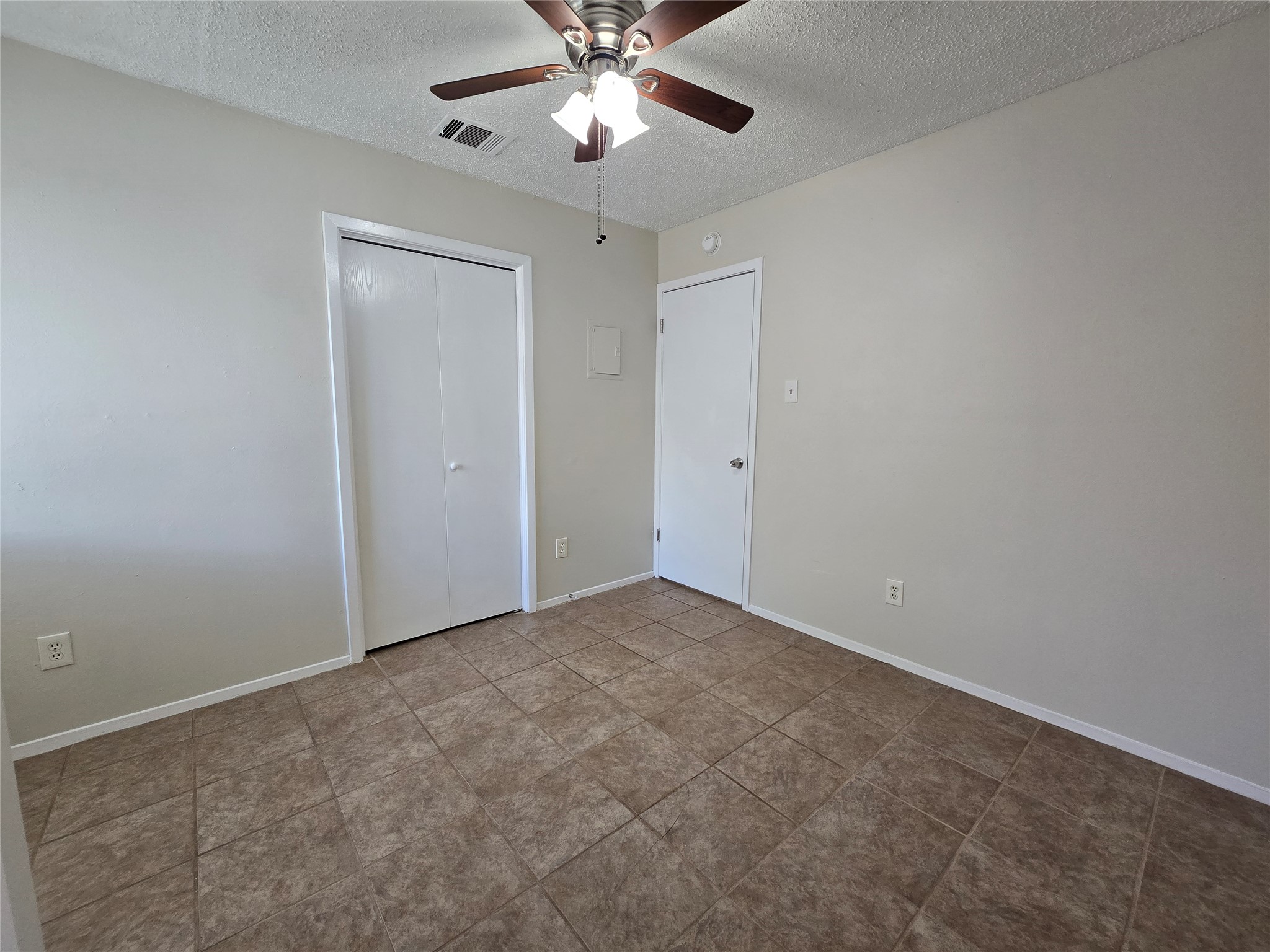 6206 Buffalo Pass, Unit A Austin, TX 78745 - Photo 13 of 24 Functional bedroom featuring practical tile flooring and a refreshing ceiling fan.