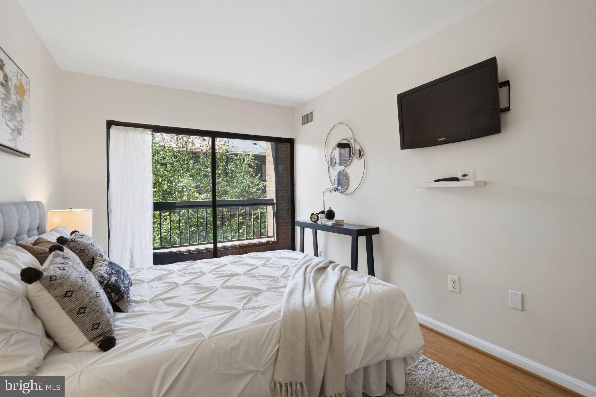 3225 Grace Street Northwest, Unit 226 Washington, DC 20007 - Photo 28 of 45 a bedroom with a bed a tv and a window