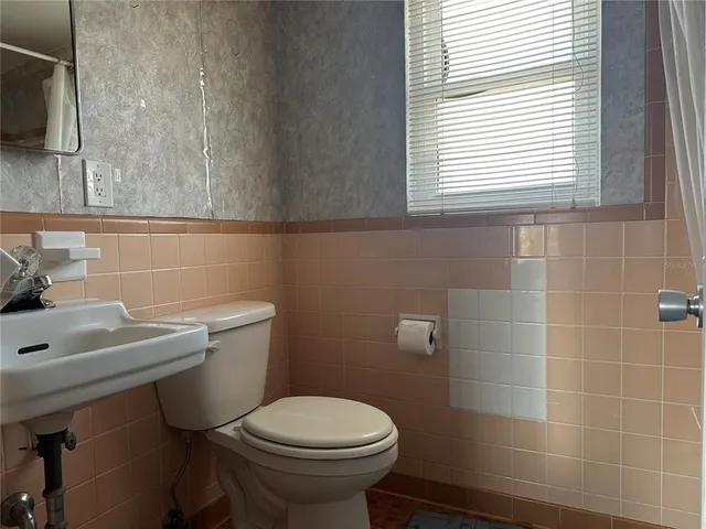 a bathroom with a sink a toilet and a window