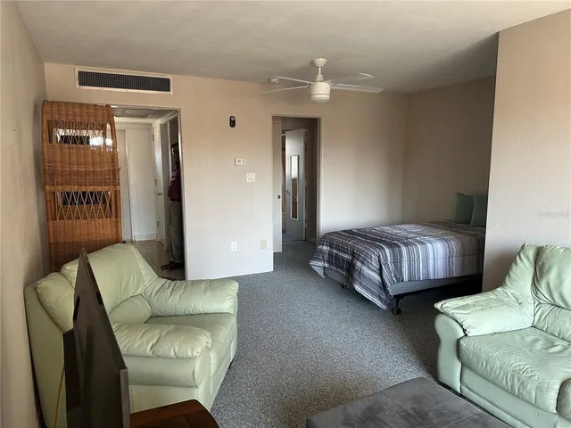 a bedroom with bed couch and window