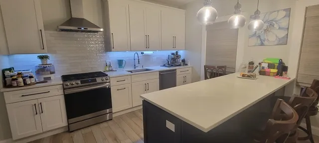 a kitchen with a stove cabinets and wooden floor