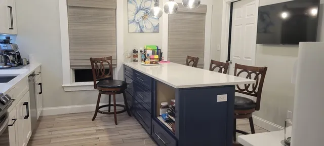 a view of a kitchen area with furniture and wooden floor