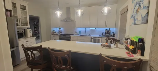 a kitchen with stainless steel appliances a dining table and chairs