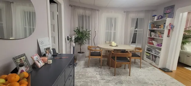 a living room with furniture a bookshelf and a window