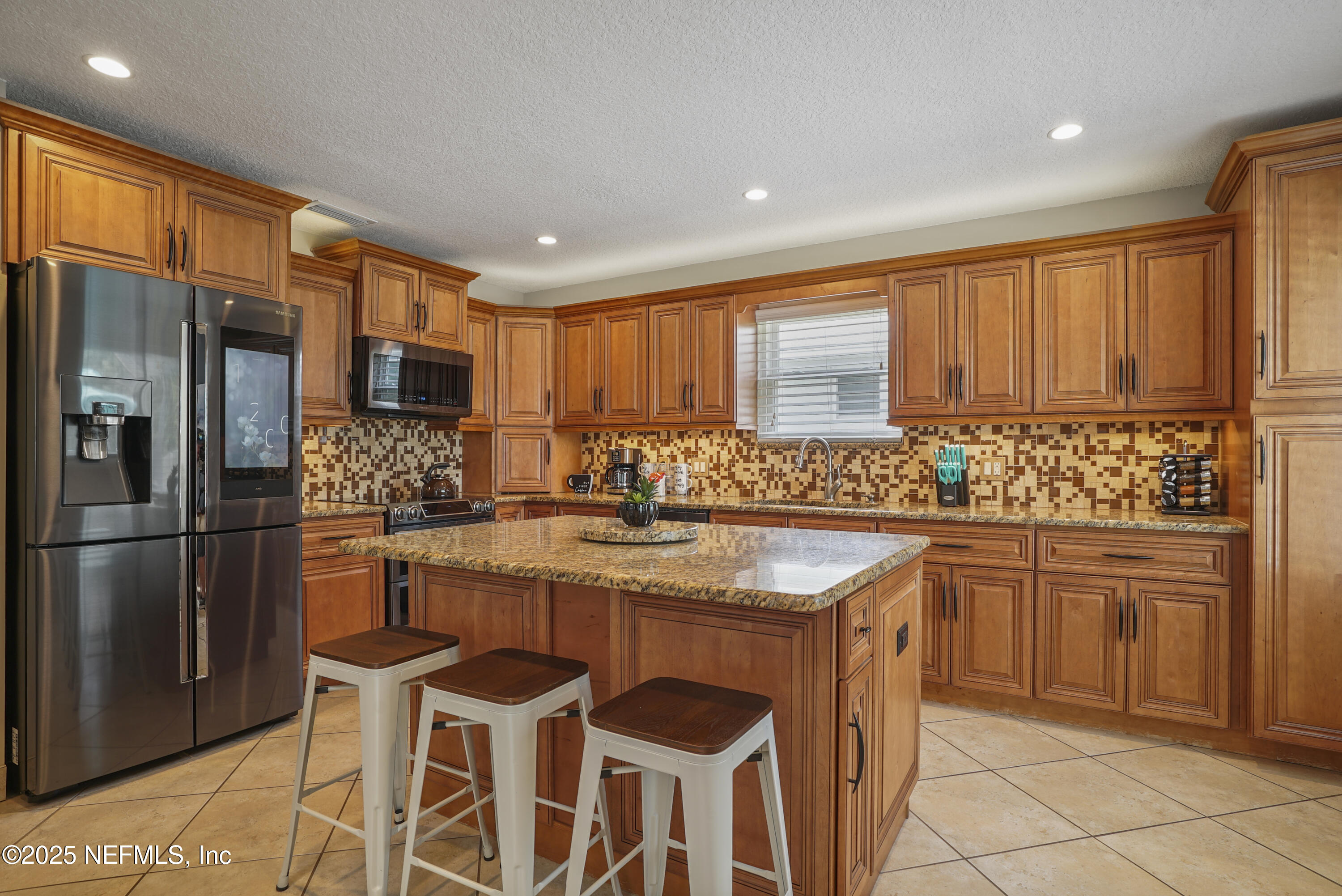 4041 Pine Run Circle St. Augustine, FL 32086 - Photo 36 of 57 a kitchen with stainless steel appliances granite countertop a stove a sink a microwave a refrigerator and chairs