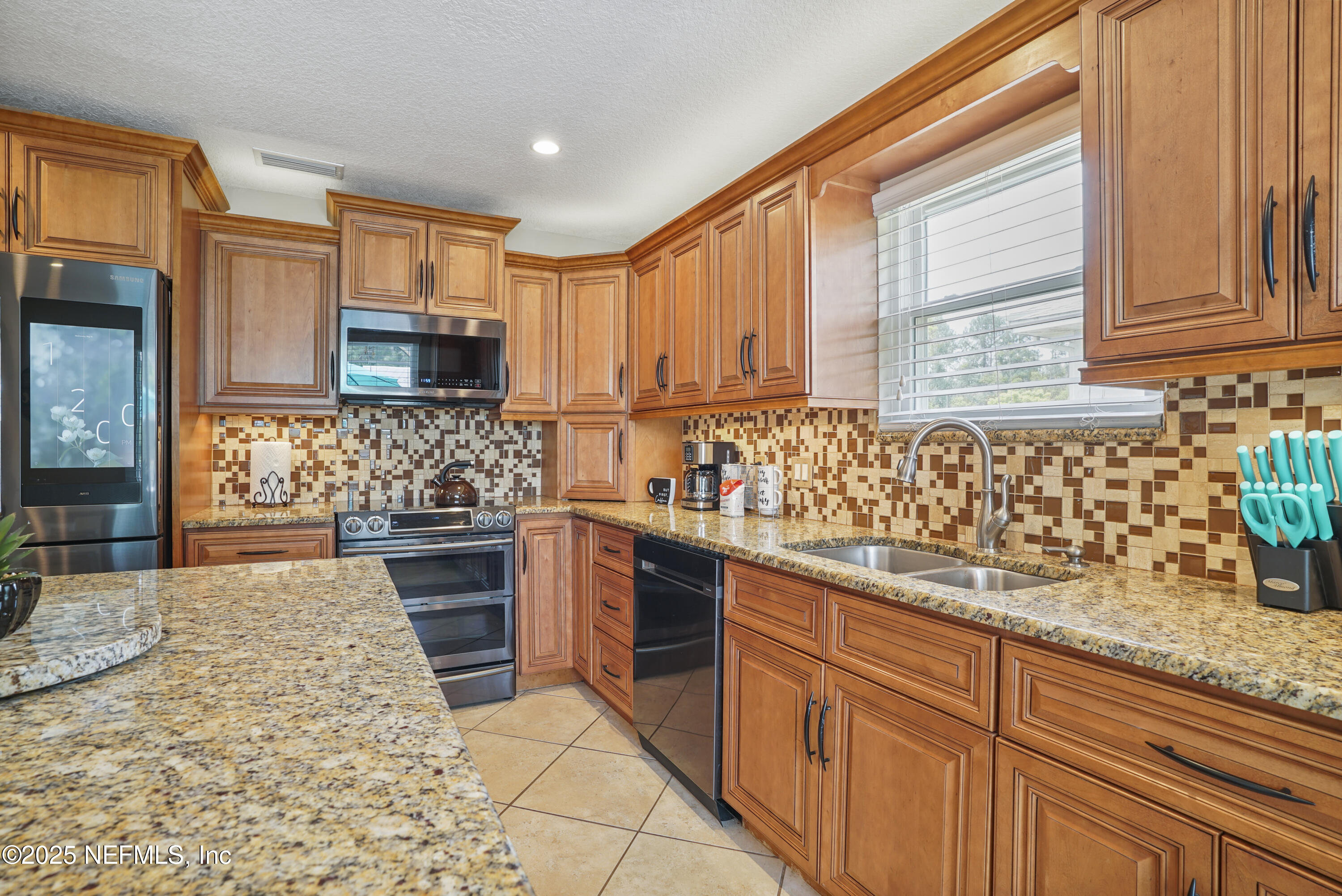 4041 Pine Run Circle St. Augustine, FL 32086 - Photo 38 of 57 a kitchen with stainless steel appliances granite countertop a stove a sink and a microwave