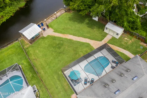 an aerial view of residential houses with outdoor space and lake view
