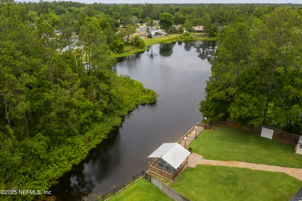 an aerial view of a house with swimming pool patio and lake view