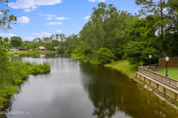 an aerial view of a house with a garden and lake view