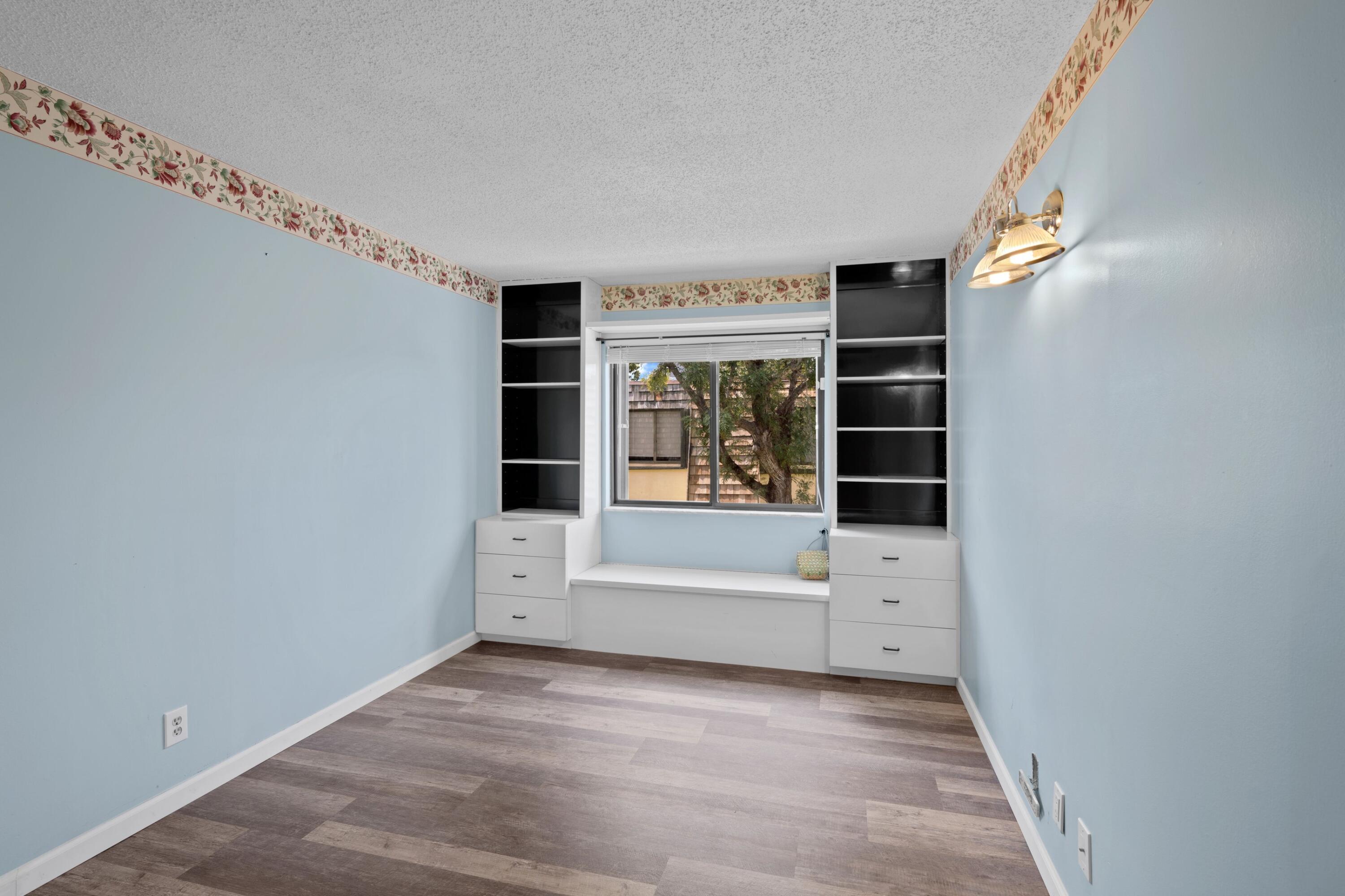 109 Woodland Road Palm Springs, FL 33461 - Photo 13 of 20 a view of an empty room with a fireplace and a window