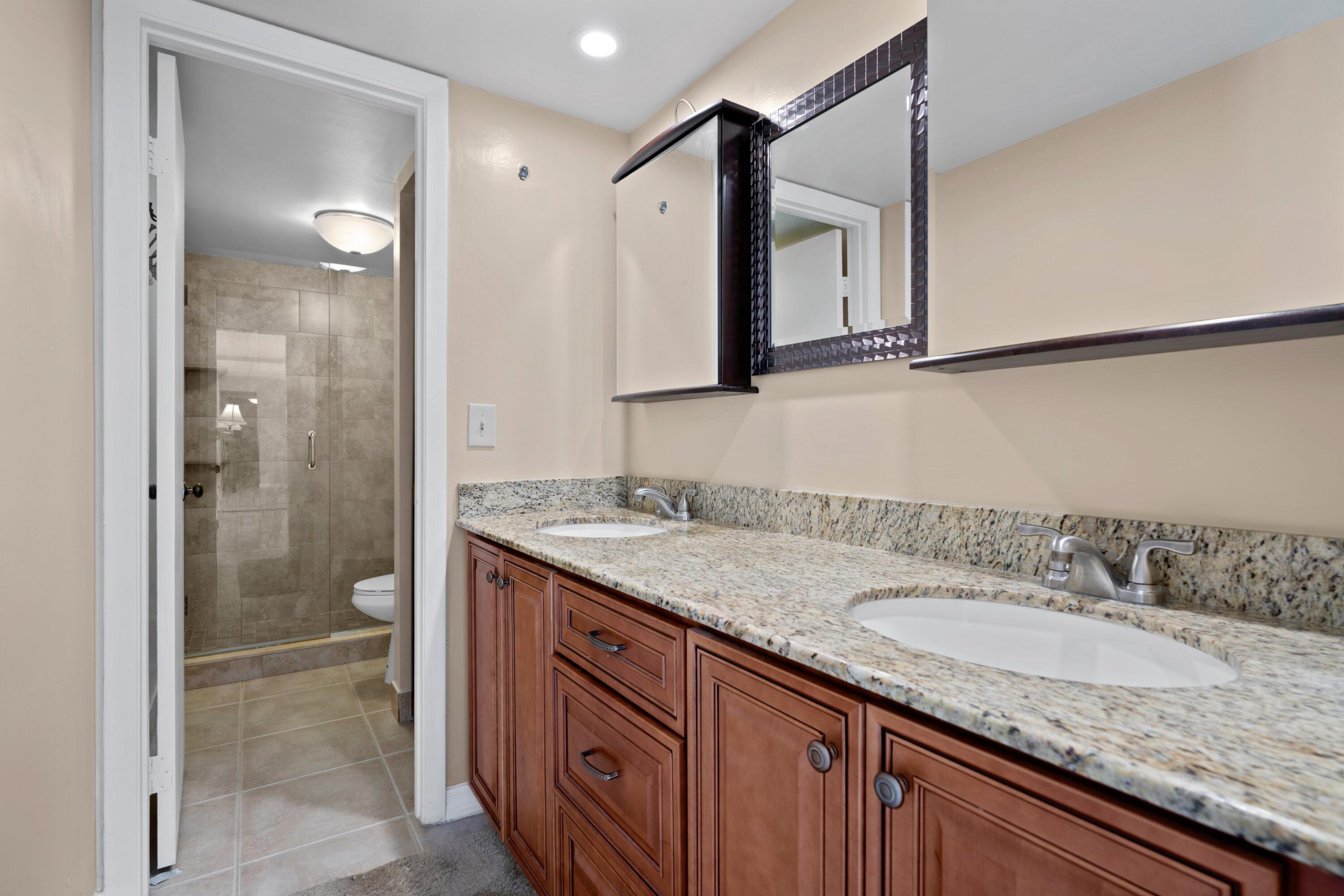 109 Woodland Road Palm Springs, FL 33461 - Photo 19 of 20 a bathroom with a granite countertop sink and a mirror